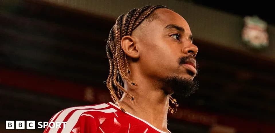 Jugador con trenzas en camiseta roja en estadio