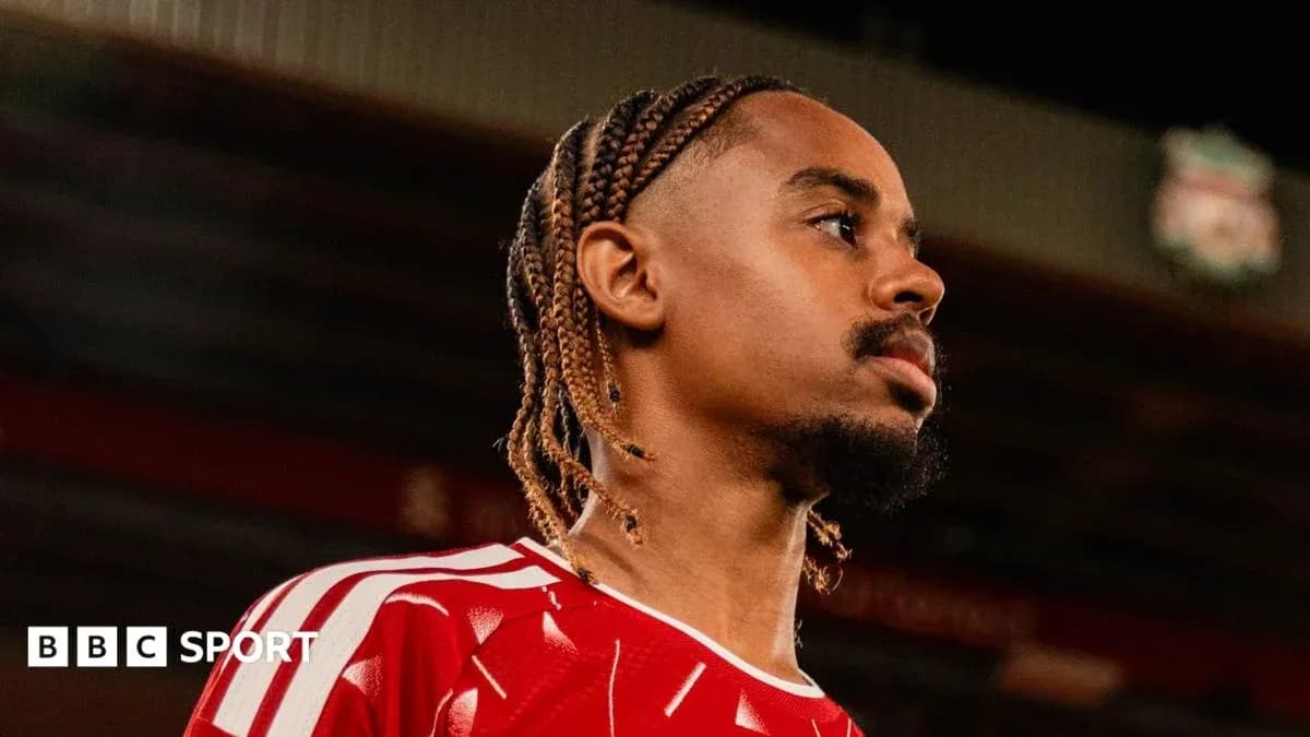 Jugador con trenzas en camiseta roja en estadio