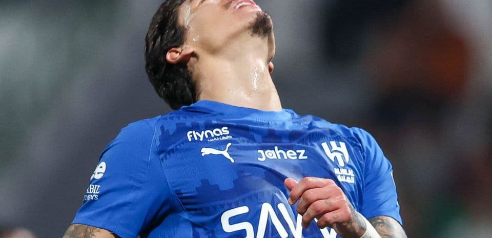 Jugador de fútbol en camiseta azul con expresión de frustración