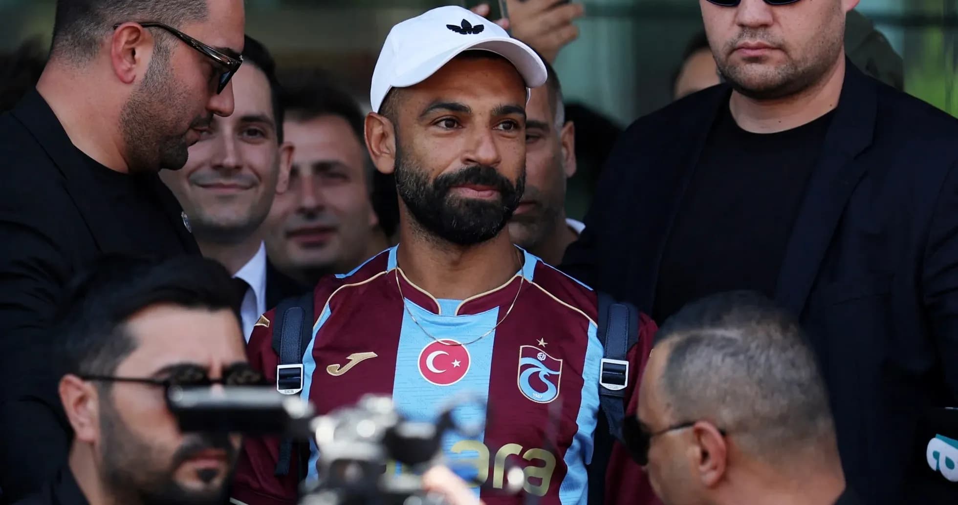 Jugador de Trabzonspor rodeado de seguridad en la llegada