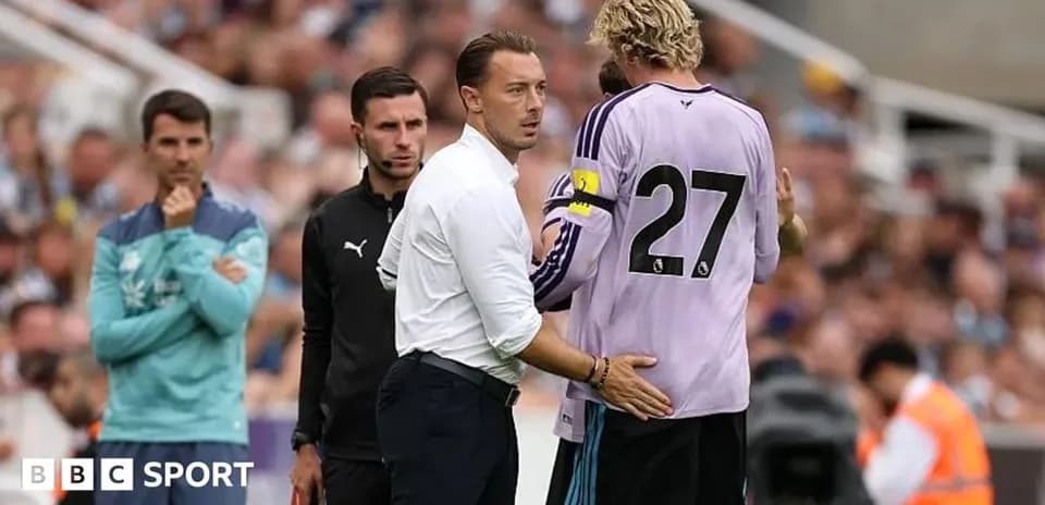 Entrenador hablando con el portero durante un partido