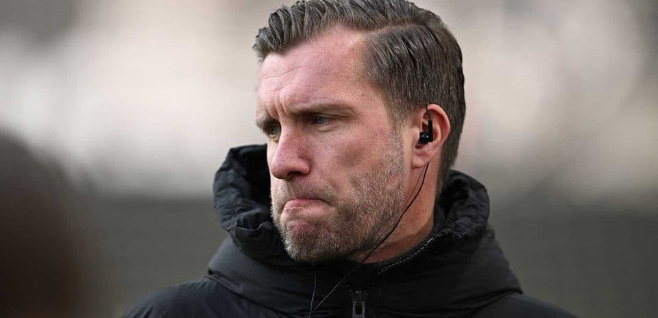 Entrenador con auriculares en campo de entrenamiento