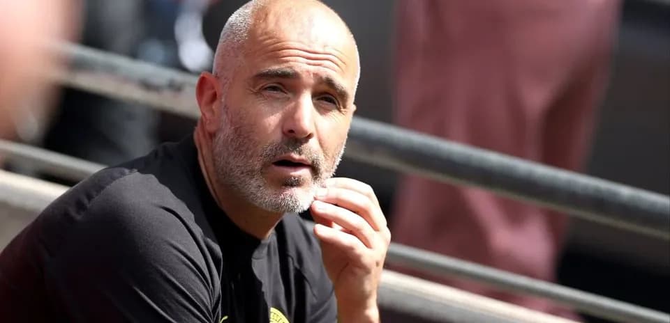 Entrenador sentado en el banquillo durante el partido