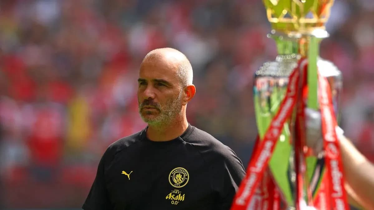 Entrenador de Manchester City junto al trofeo