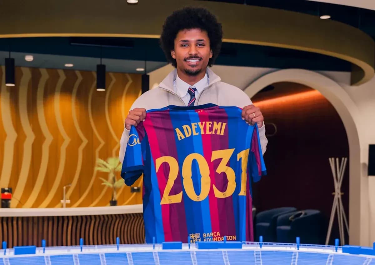 Jugador sosteniendo camiseta de FC Barcelona con nombre Adeyemi