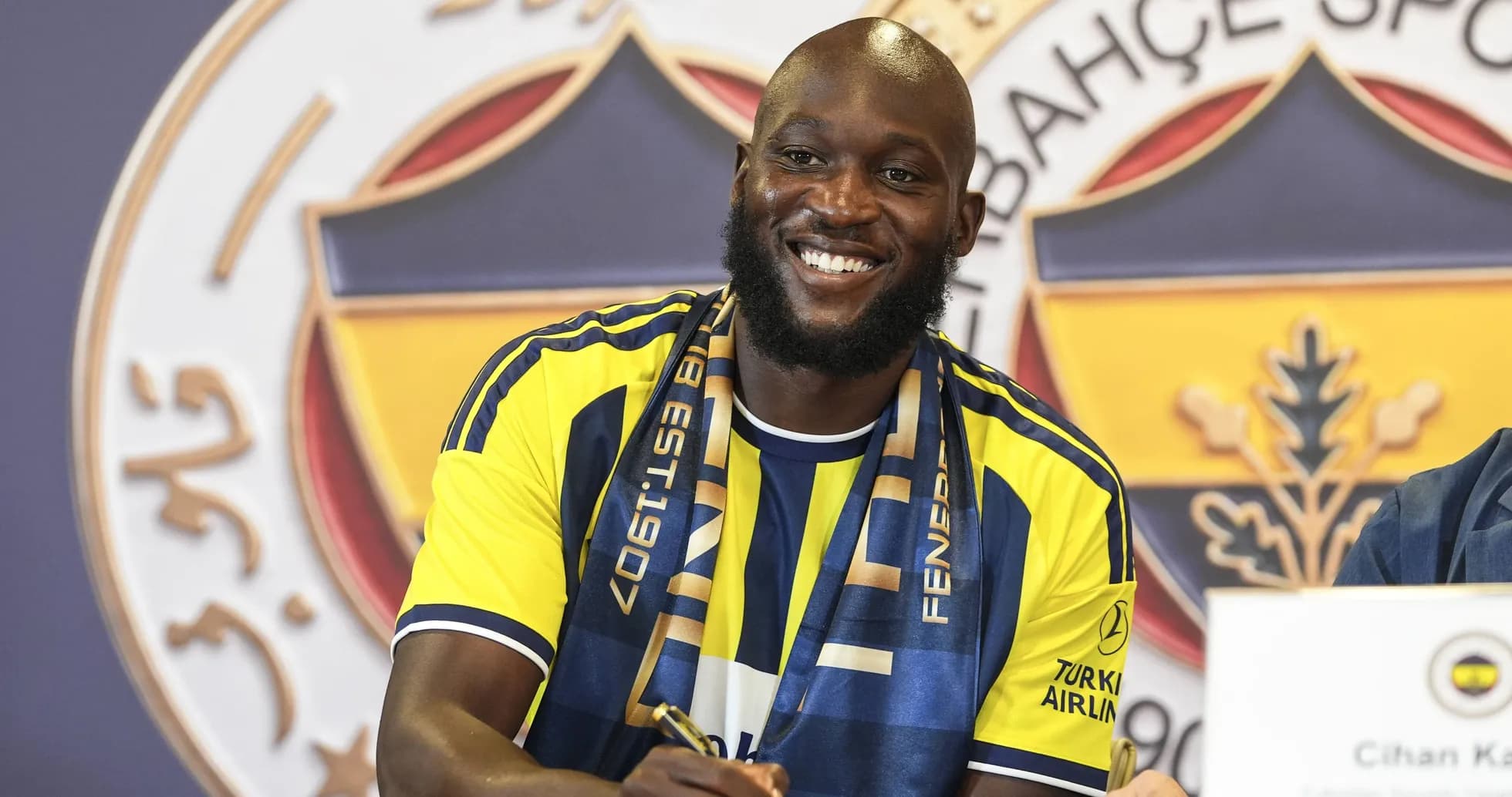 Jugador firmando contrato con Fenerbahçe en rueda de prensa