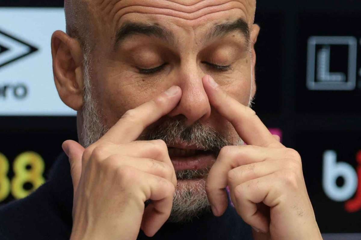 Entrenador tocando su rostro durante conferencia de prensa