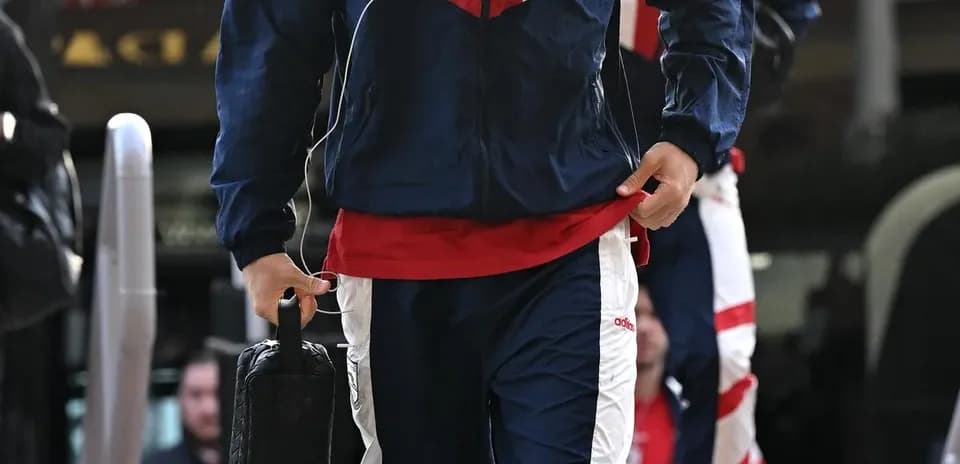 Jugador llegando con ropa de entrenamiento y auriculares