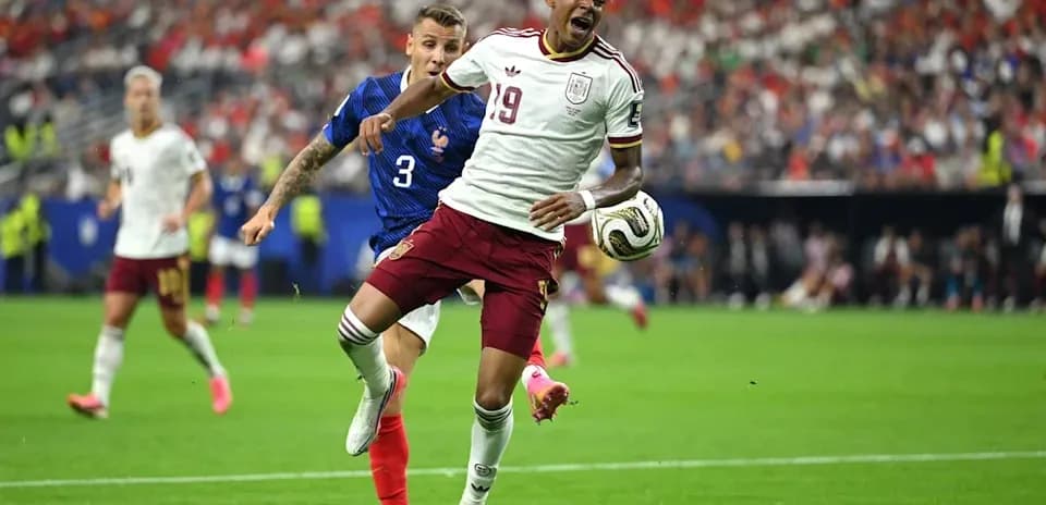 Jugador de España driblando mientras es perseguido por francés