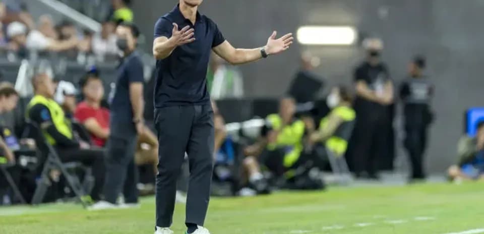 Entrenador dando instrucciones desde la línea de banda