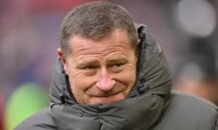 Entrenador con abrigo en el campo de fútbol