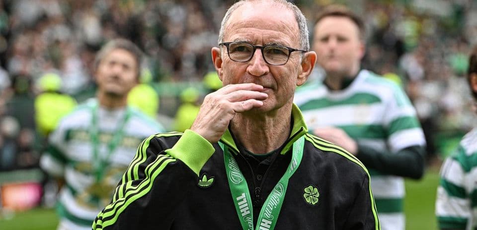 Entrenador de pie en el campo con medalla