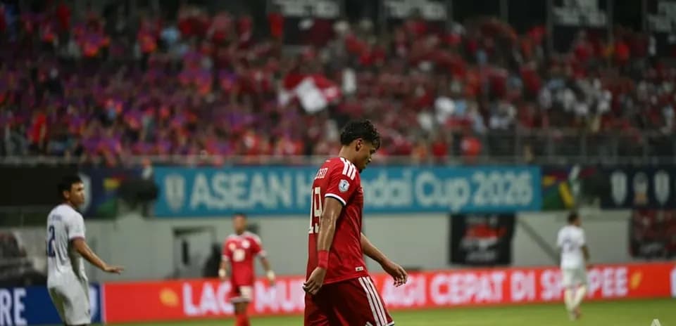 Jugador caminando cabizbajo en partido de fútbol