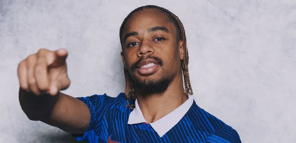 Jugador señalando con camiseta azul de fútbol