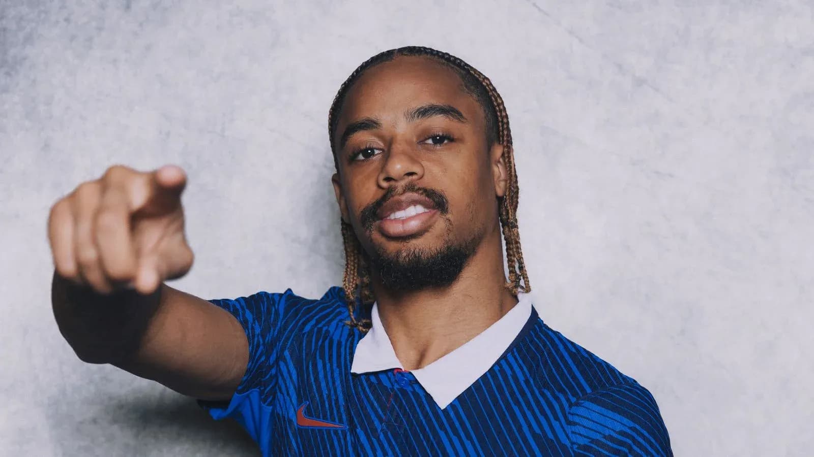 Jugador señalando con camiseta azul de fútbol