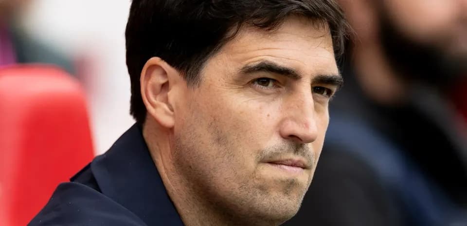 Entrenador observando desde el banquillo del estadio