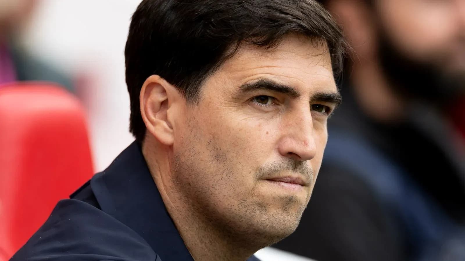 Entrenador observando desde el banquillo del estadio