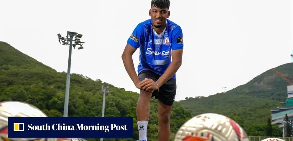 Jugador posando en campo de fútbol con balones