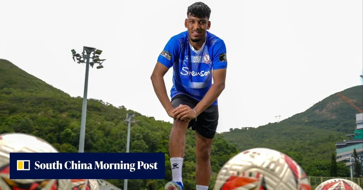 Jugador posando en campo de fútbol con balones