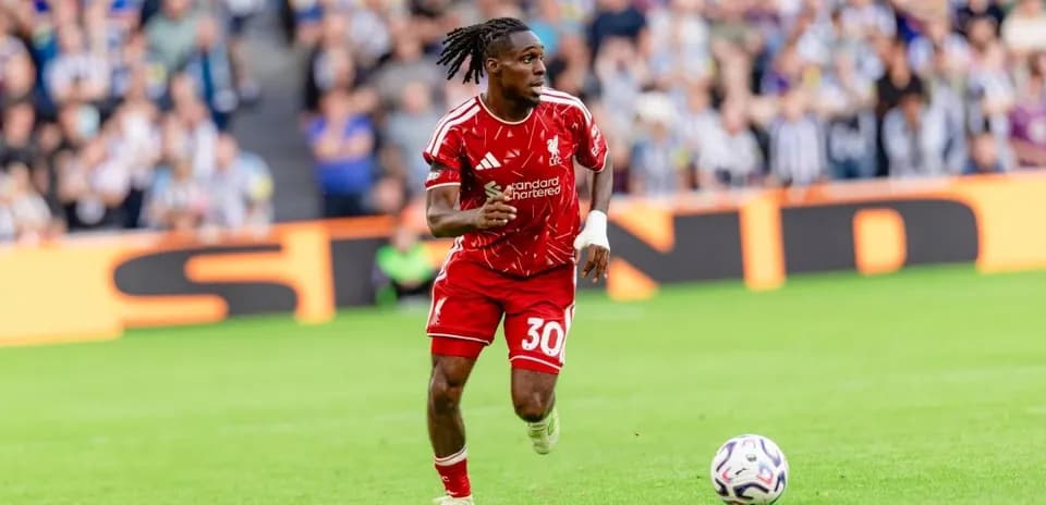 Jugador de Liverpool corriendo tras el balón en campo