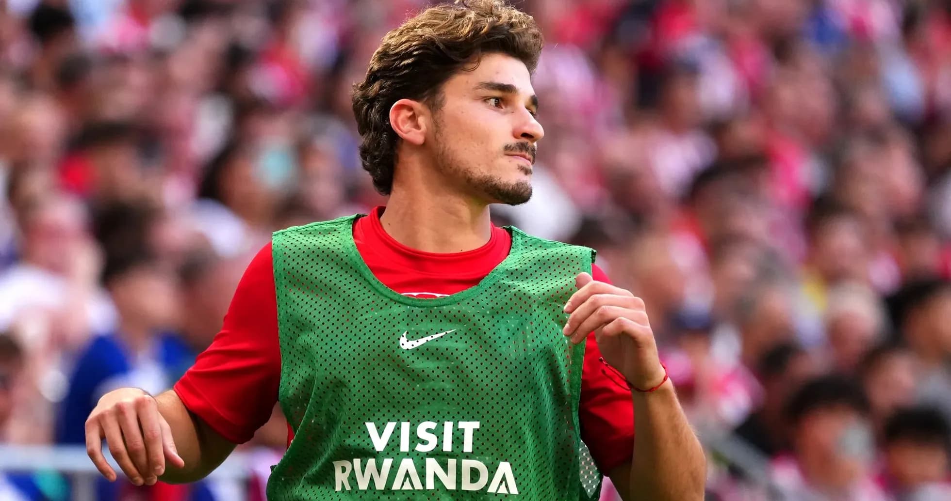 Jugador en el banquillo con chaleco de calentamiento