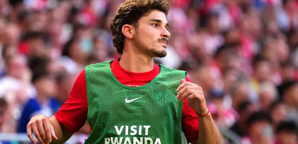 Jugador en el banquillo con chaleco de calentamiento