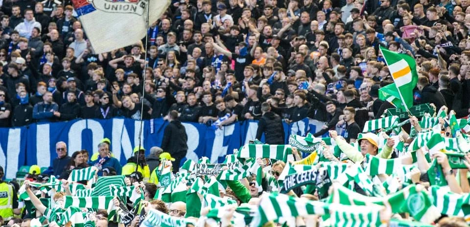 Aficionados con bufandas en un partido de fútbol