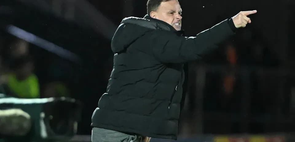 Entrenador señalando instrucciones desde la línea de banda