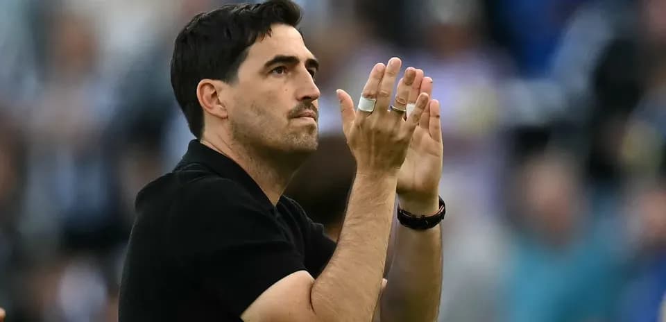 Entrenador aplaudiendo en el campo de juego