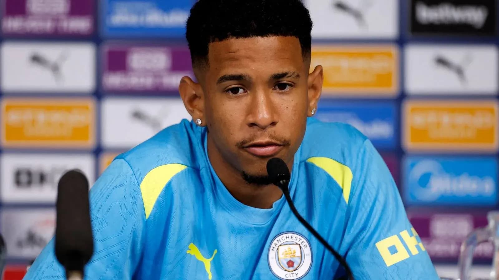 Jugador en rueda de prensa con camiseta de Manchester City