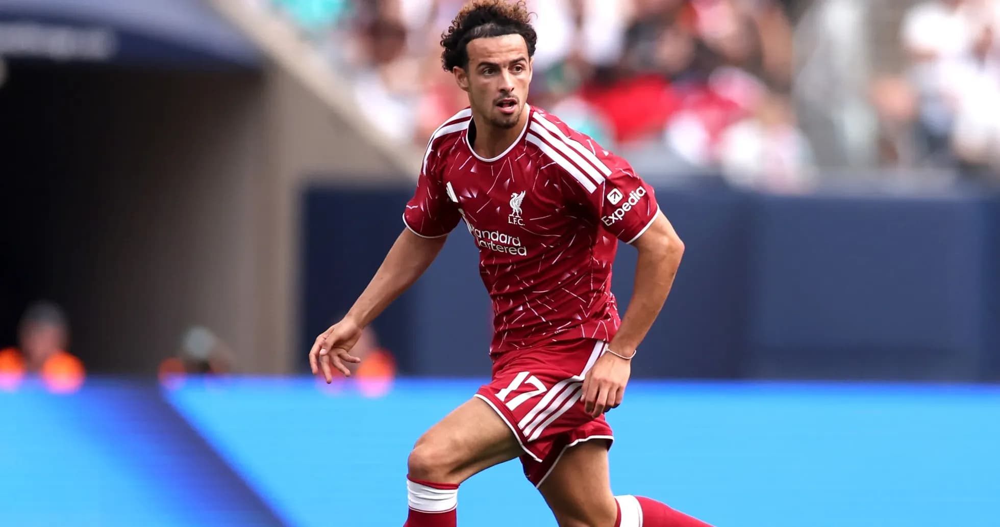 Jugador de Liverpool corriendo con balón en el campo