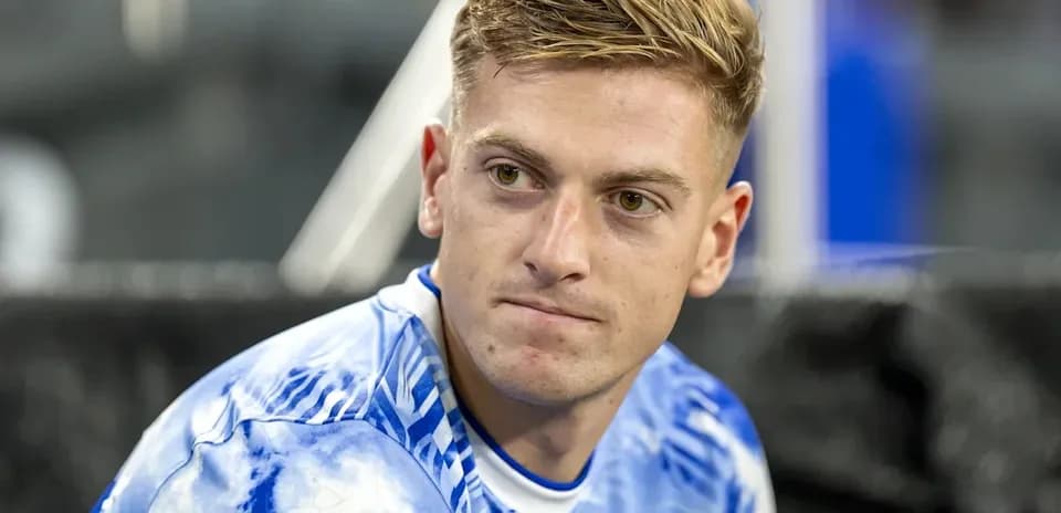 Jugador sentado con camiseta azul antes del partido