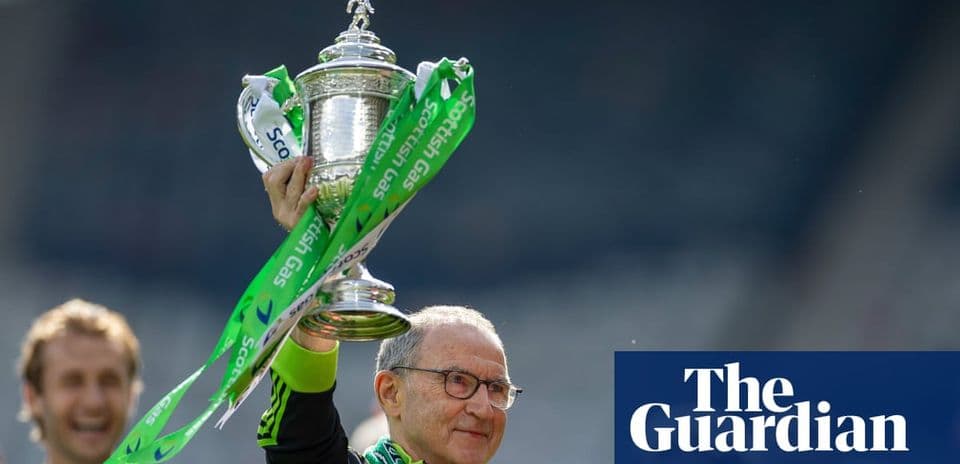 Entrenador levantando el trofeo con cintas verdes