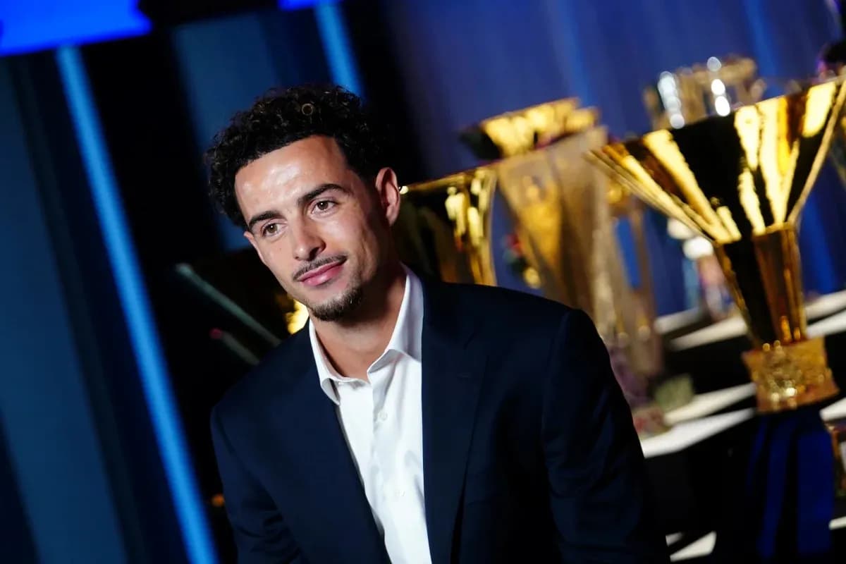 Jugador posando frente a trofeos en evento