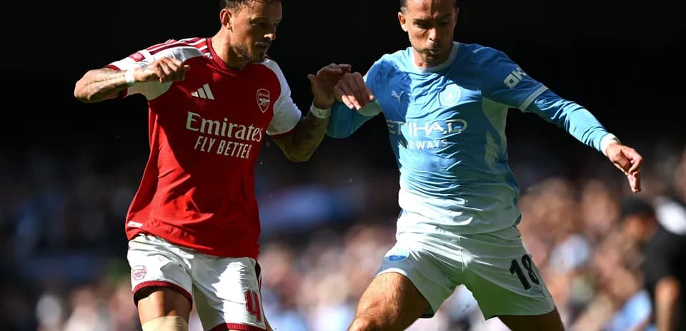 Jugadores de Arsenal y Manchester City compitiendo por el balón