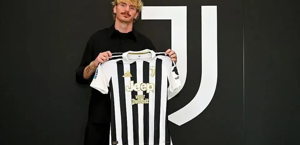 Jugador sosteniendo camiseta de Juventus en presentación