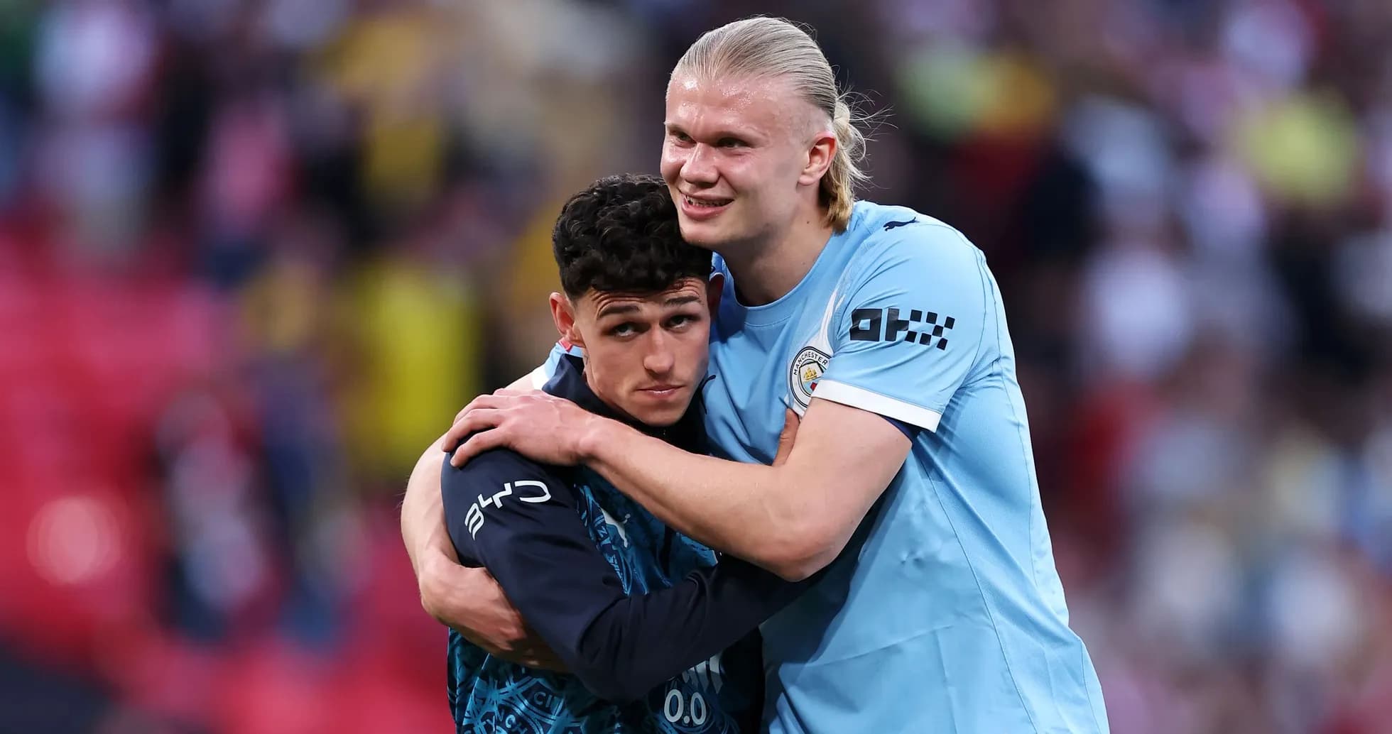 Jugadores de Manchester City abrazándose en el campo