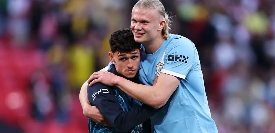 Jugadores de Manchester City abrazándose en el campo