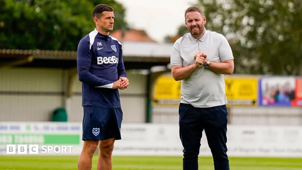 Entrenador y jugador conversando en el campo de entrenamiento