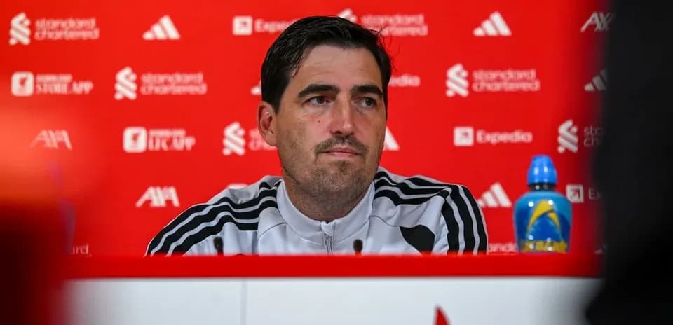 Entrenador en conferencia de prensa con fondo rojo