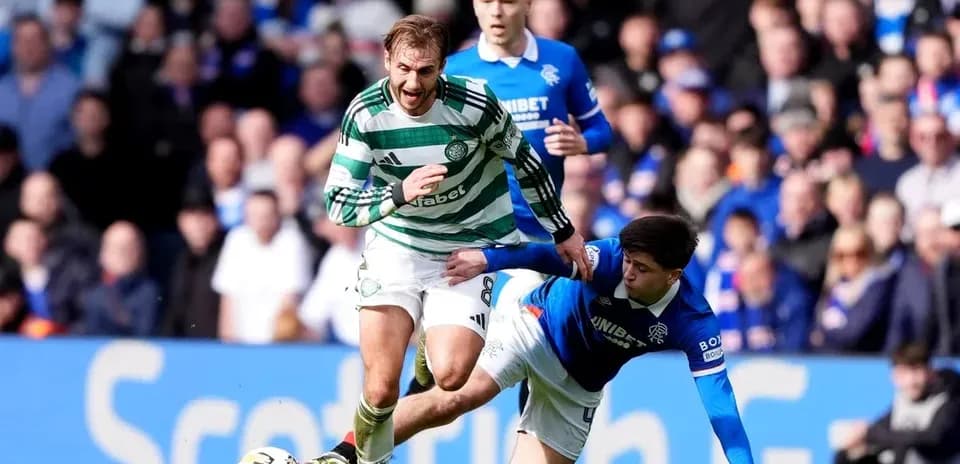 Jugador de Celtic esquivando a rival de Rangers