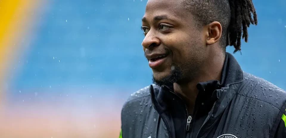 Jugador de fútbol con chaqueta de entrenamiento bajo la lluvia