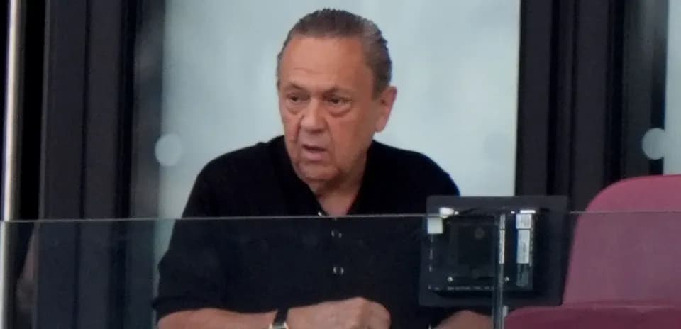 Hombre en un palco observando un evento deportivo