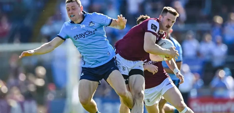 Jugador de Galway avanzando mientras es tackleado por Dublín