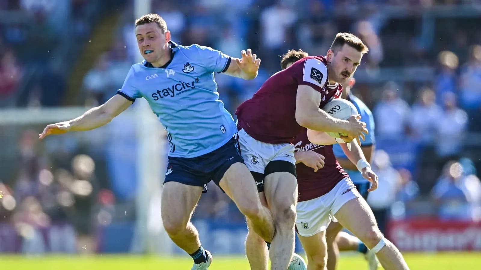 Jugador de Galway avanzando mientras es tackleado por Dublín