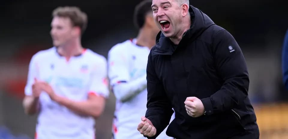 Entrenador celebrando con jugadores al fondo