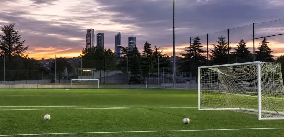 Campo de fútbol con dos balones al atardecer