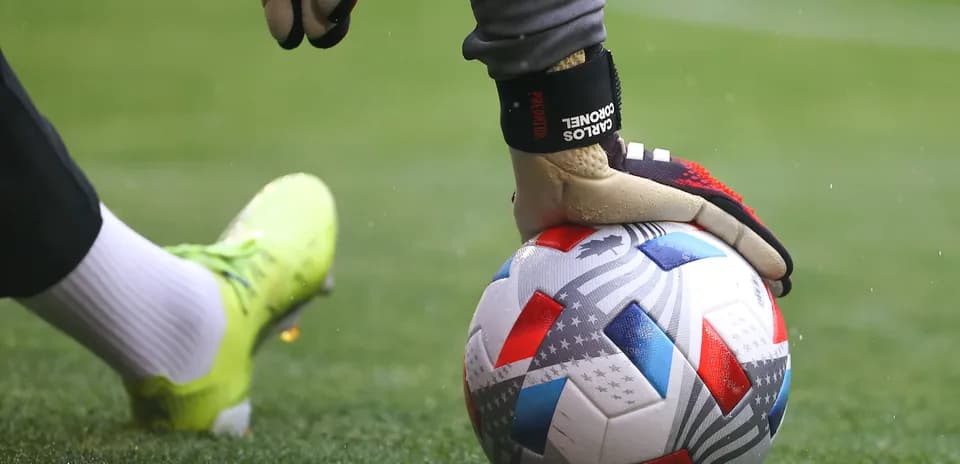 Portero sosteniendo balón en el campo de juego