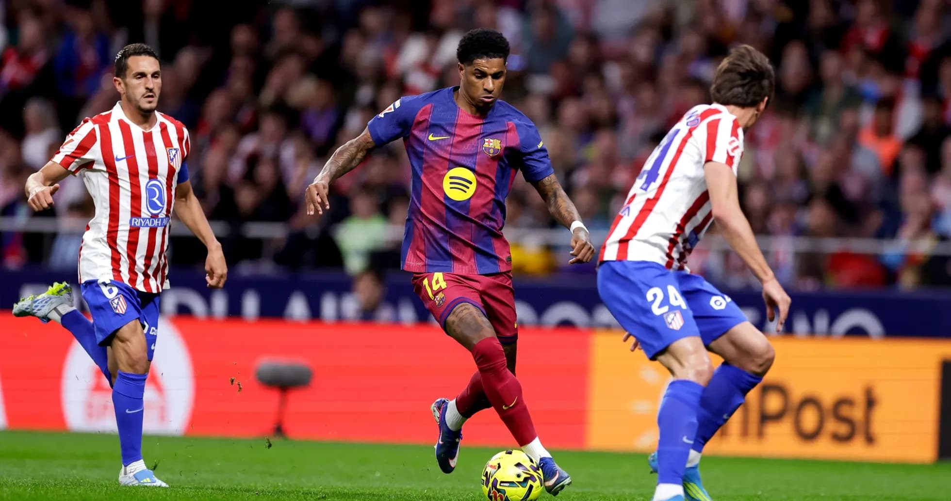 Jugador de Barcelona driblando a defensores de Atlético