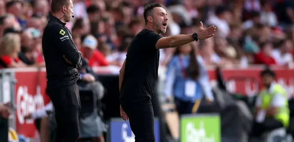 Entrenador gesticulando durante un partido de fútbol